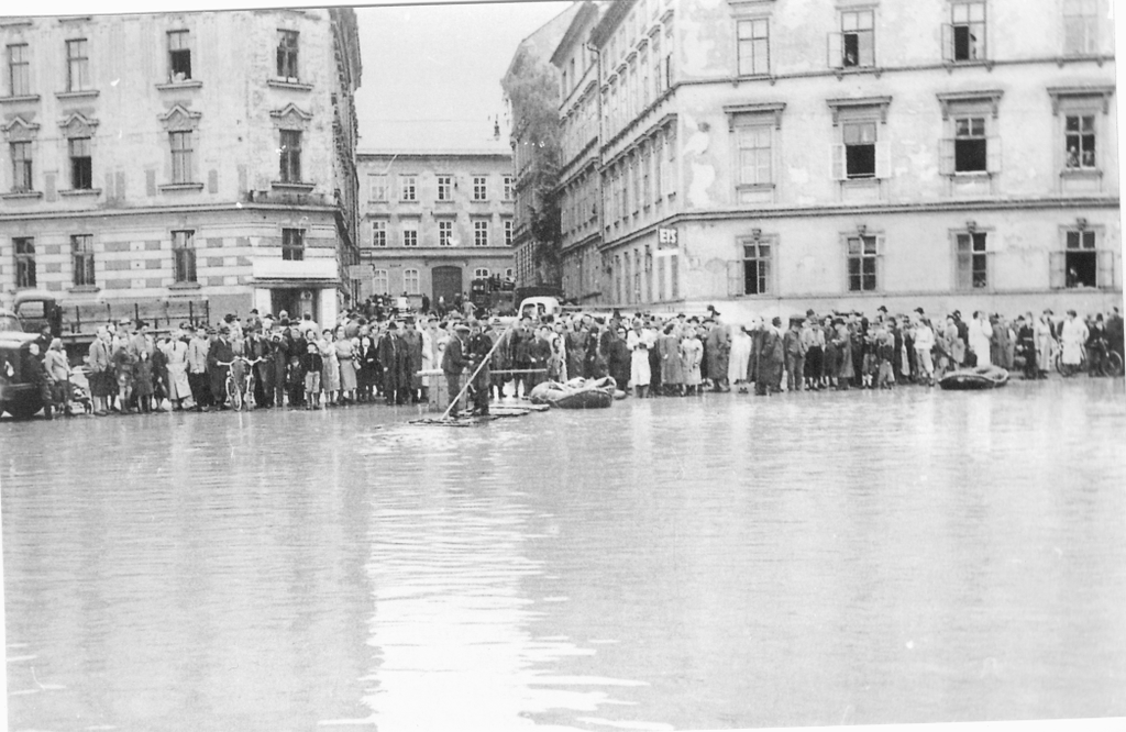 Eine Menschenmenge steht am Rand des Hochwassers.