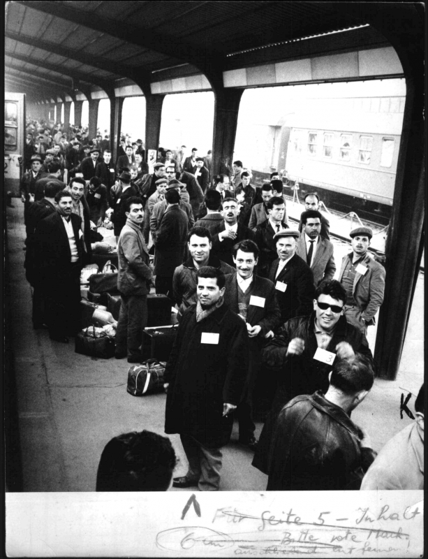 Männer mit Koffern am Bahnsteig