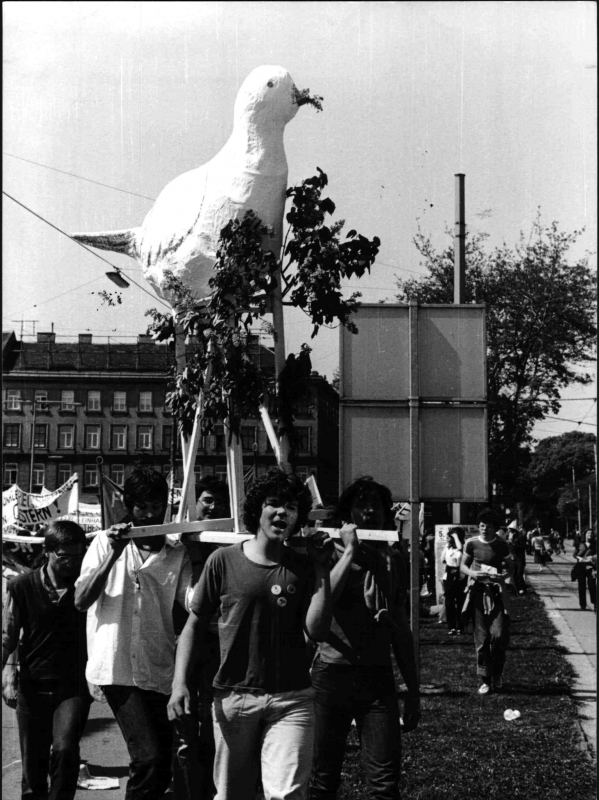 Eine Gruppe junger Demonstranten trägt eine Friedenstauben-Skulptur auf den Schultern.