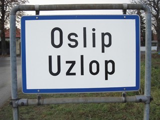 Zweisprachige Ortstafel im Nordburgenland. Laut Volkszählung von 2001 leben in der Gemeinde Oslip/Uzlop 1.323 Menschen. Davon gaben die Hälfte (667) Burgenlandkroatisch (Gradišćanskohrvatski) und etwas mehr als 41 % (545) Deutsch als Umgangssprache an